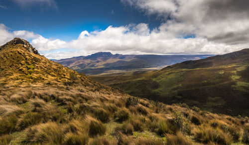 Scenic view of mountain range against cloudy sky