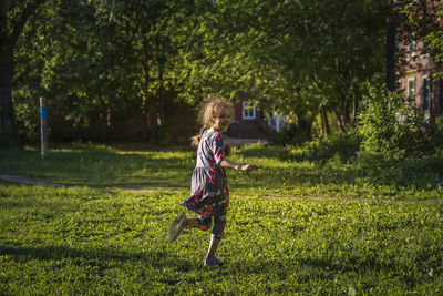 Full length of woman running on grass