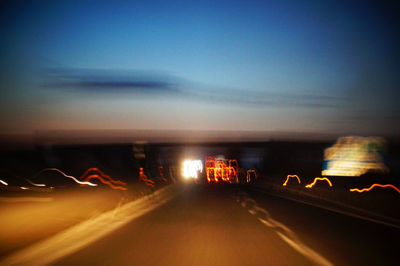 Cars on road against sky at night