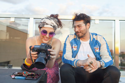 Young woman showing pictures to her friend