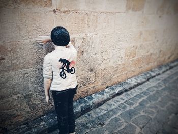 Rear view of man standing against wall