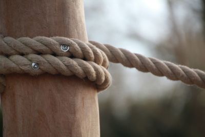 Close-up of rope rolled up on wood