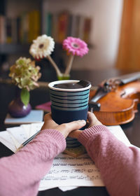 Midsection of person holding flower at home