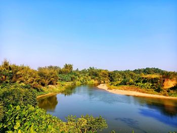 Scenic view of lake against clear blue sky