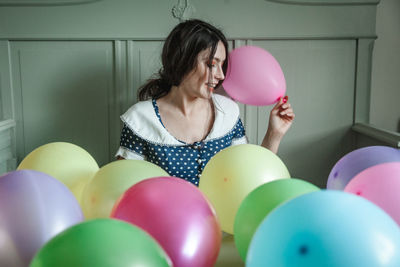 Full length of woman holding colorful balloons