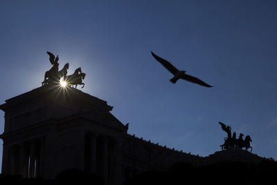 Low angle view of silhouette statue against sky