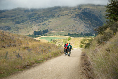 Rear view of man riding bicycle on road