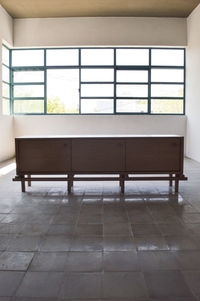 Wooden furniture light and shadow, light wood credenza contrasting with light and shadow, vegetation