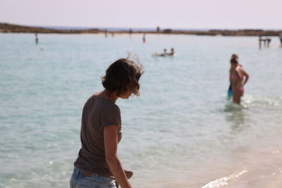 Rear view of people standing on beach