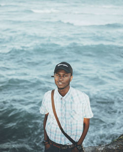 Portrait of smiling young man standing in sea