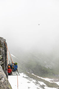 Drone captures aerial video of climbers on portaledge, rock climbing.