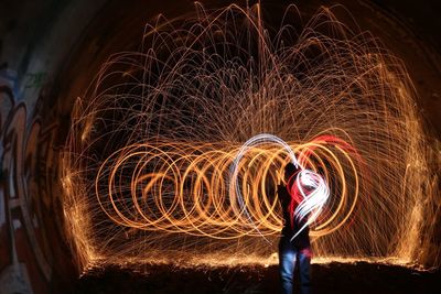 Man spinning wire wool at night