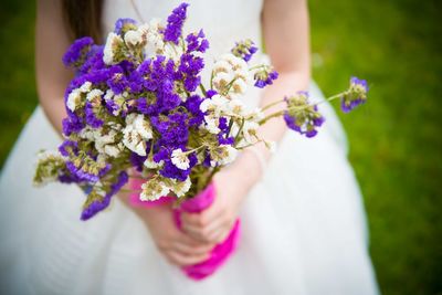 Midsection of woman holding bouquet