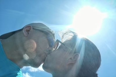 Low angle view of couple kissing outdoors