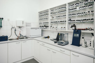 Laptop by device and containers arranged in chemist store