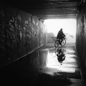 People riding bicycle in tunnel