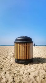 Lifeguard hut on beach against clear blue sky