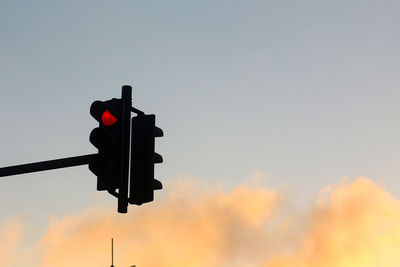 Low angle view of road signal against sky