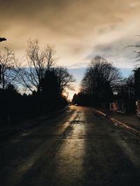 Road amidst bare trees against sky