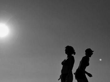 Silhouette people standing against sky