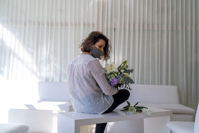 Woman holding flowers at home