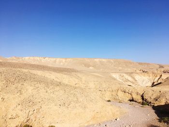 Scenic view of desert against clear blue sky