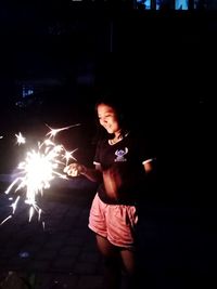 Young woman with arms outstretched in the dark