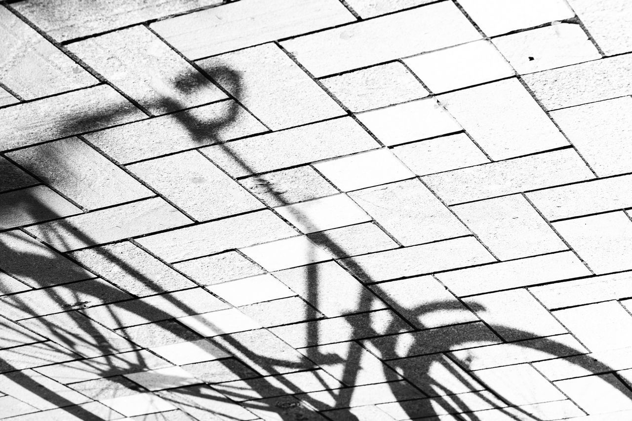 HIGH ANGLE VIEW OF SHADOW ON TILED FLOOR