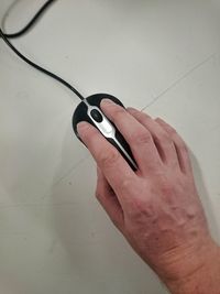 Cropped hand of person using computer mouse on desk in office