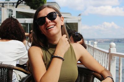 Smiling young woman sitting at outdoor restaurant