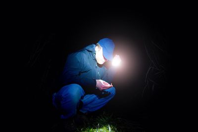 Rear view of man sitting at night