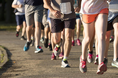 Low section of people running on street