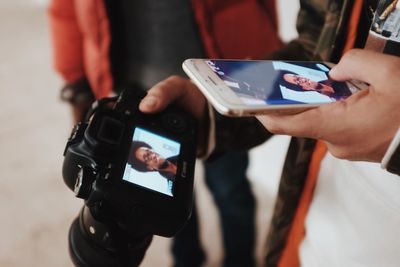 Midsection of woman photographing with mobile phone