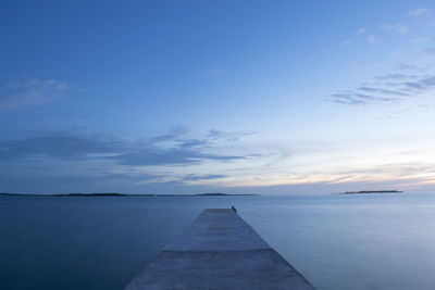 Pier over sea against sky during sunset