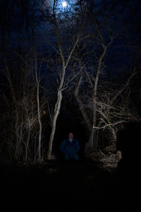 Man sitting on field at night