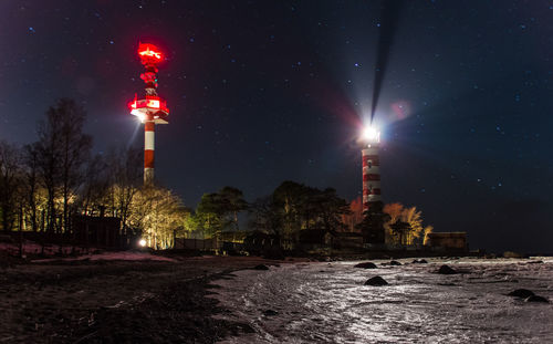 Illuminated lighthouse against sky at night