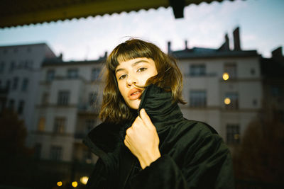 Portrait of smiling young woman standing in city