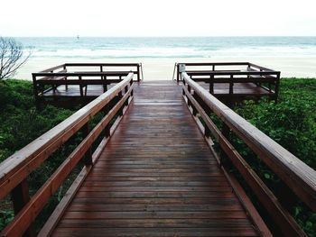 View of wooden walkway to sea on beach