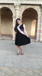 Full length portrait of young woman wearing bridesmaid sash at vardhman fantasy amusement park