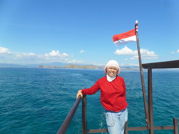 Portrait of woman standing by sea against sky