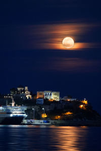 Illuminated sea against sky at night