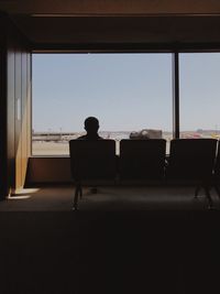 Rear view of men sitting on chair at airport