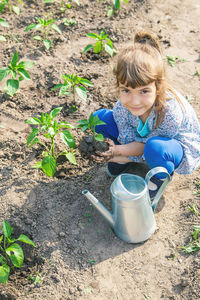 Side view of cute boy watering plants