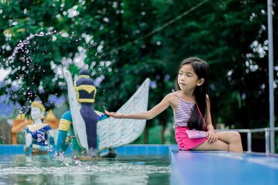 Woman in swimming pool against trees