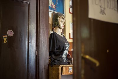 Side view of young woman standing against door