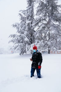 Rear view of woman skiing on snow covered field