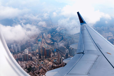 Plane to hong kong. airplane window view at the skyscrapers. overhead city view. cityscape aerial.
