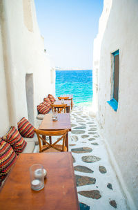 Chairs and table on beach against buildings