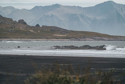 Scenic view of sea and mountains against sky