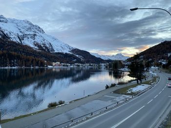 Scenic view of lake by snowcapped mountains against sky